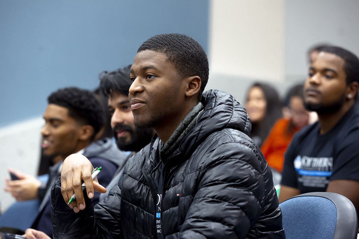 man sitting in auditorium chair listening intently