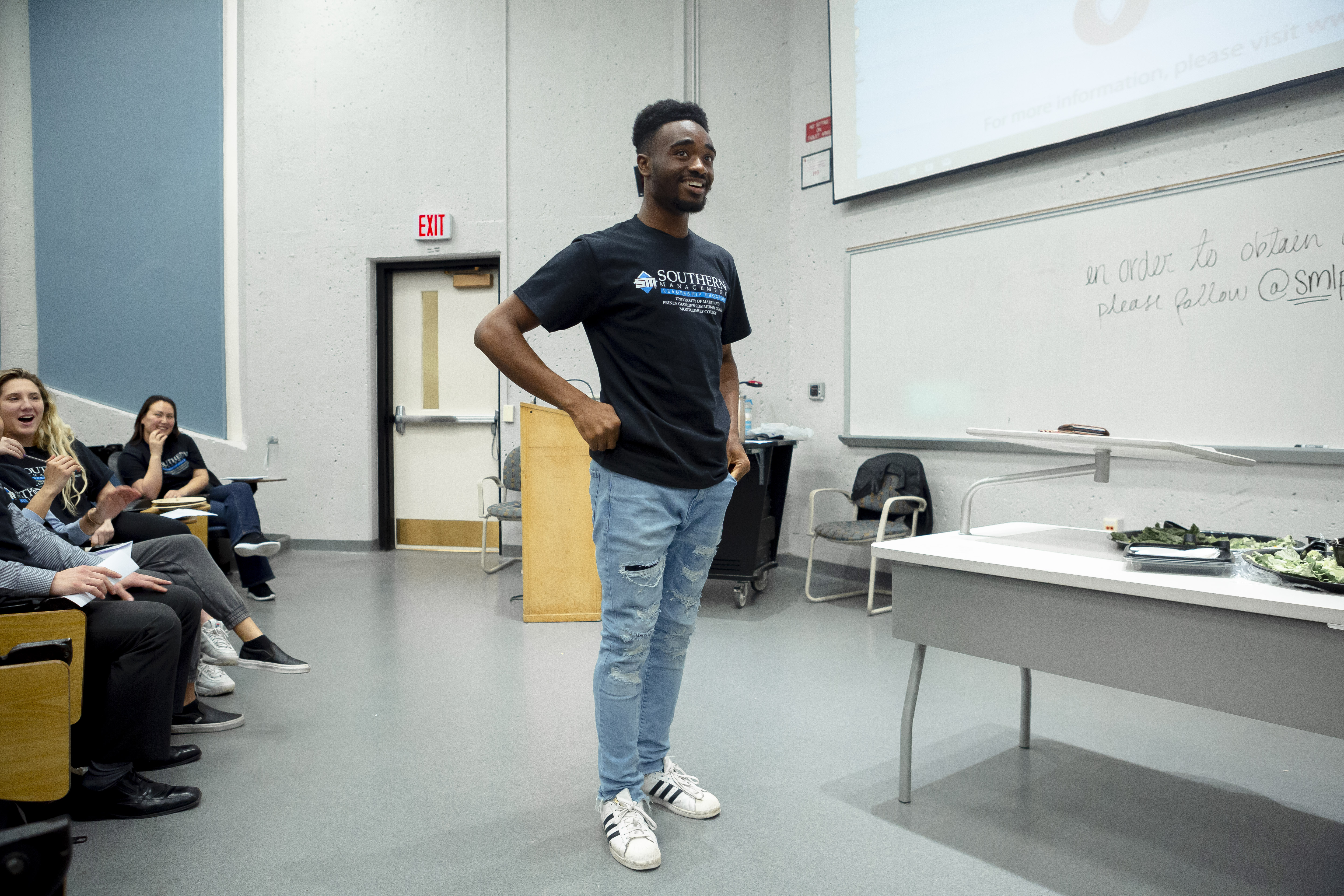 student standing at the front of the class wearing SMLP shirt