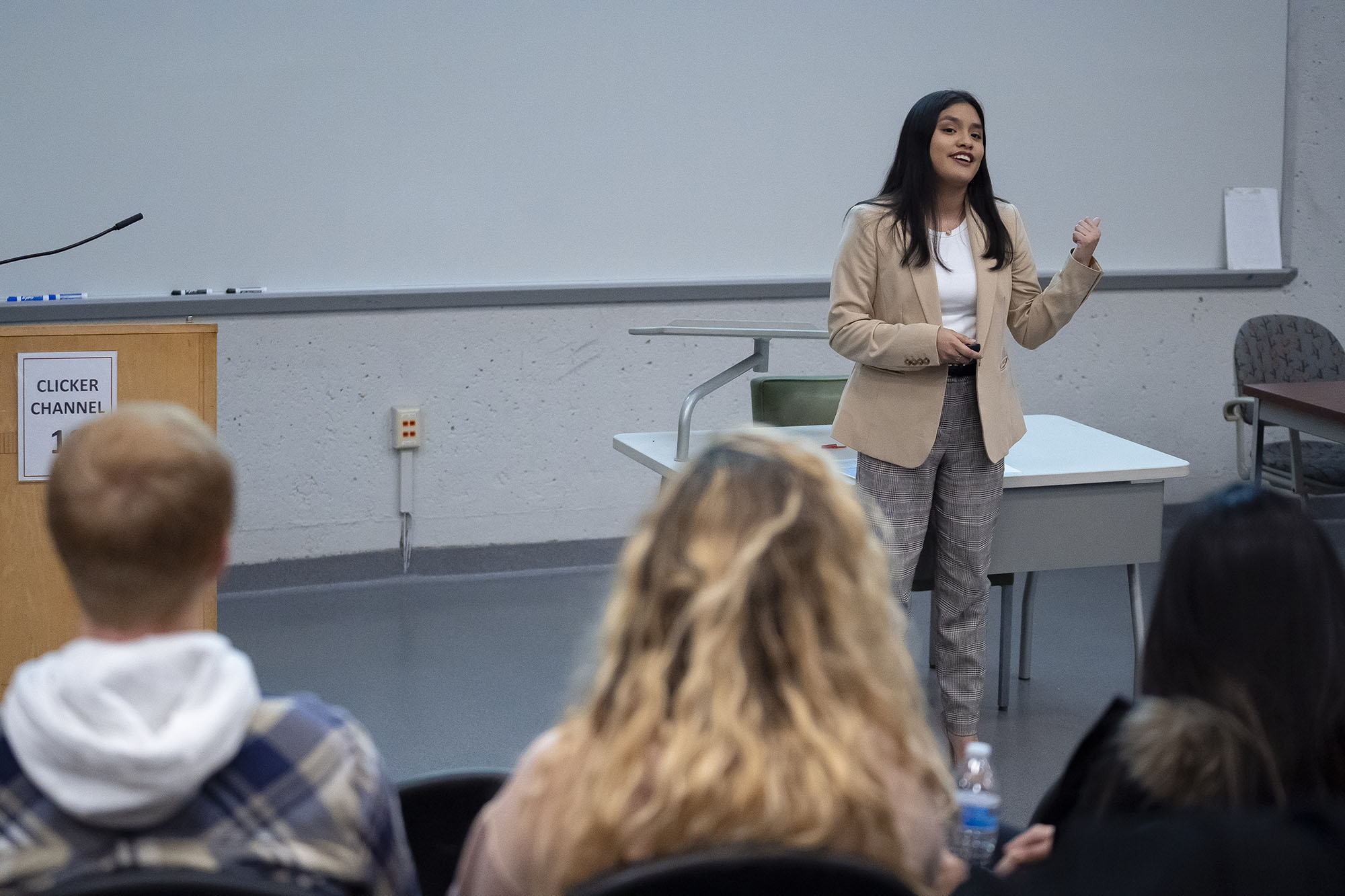 woman lecturing at front of auditorium